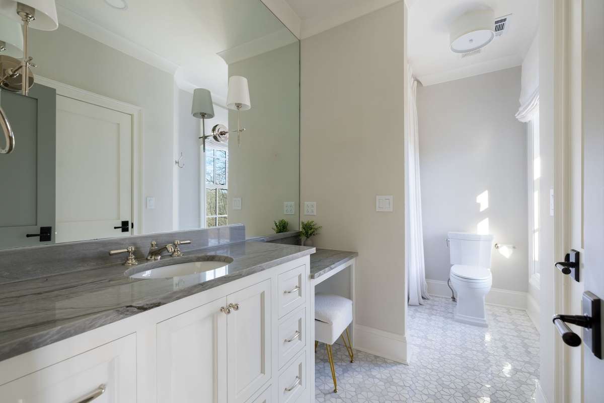 En suite bathroom with dual level vanity and walk-in closet