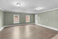 The bonus room features a combination of tile and luxury vinyl flooring, along with two large windows with views of the front yard.