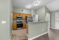 The kitchen offers a blend of style and practicality with tile flooring, new granite countertops, and stainless steel appliances including a brand new refrigerator.