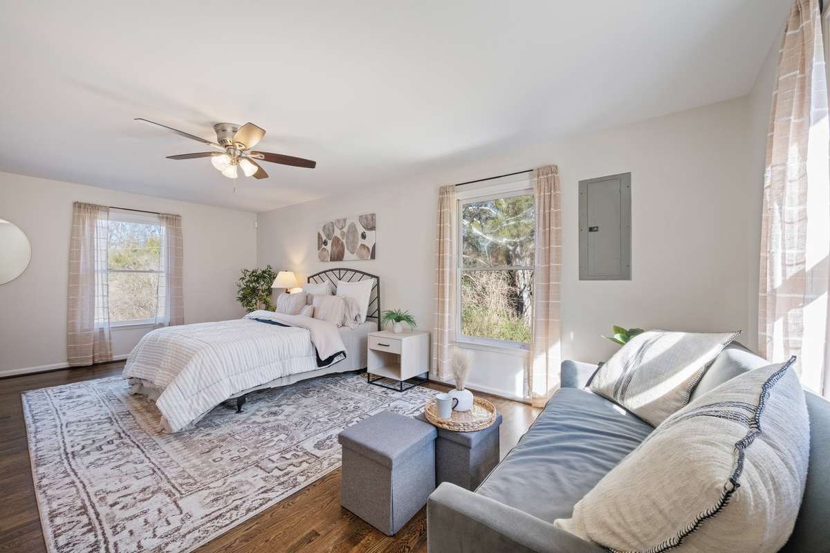 PRIMARY BEDROOM with sitting area large windows overlooking property loads of natural light