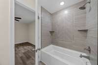 Tile surround master shower with shelves for cosmetic organization.