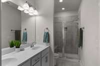 The Primary Bathroom Boasts Double Vanities and a Large Tiled Walk-In Shower.