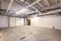 Spacious garage area located below the finished studio space offers ample room for parking, storage, or a workshop setup that also includes a half bath