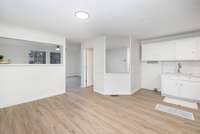 The finished studio space above the garage features a convenient kitchenette with white cabinetry, subway tile backsplash and sink, ideal for a guest suite, media room, home office, or multi-purpose flex space.