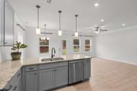 Open concept kitchen with gorgeous granite counters and contemporary lighting