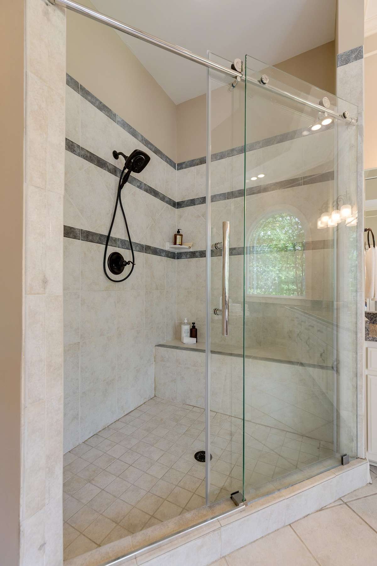 frameless shower door with bronze faucets