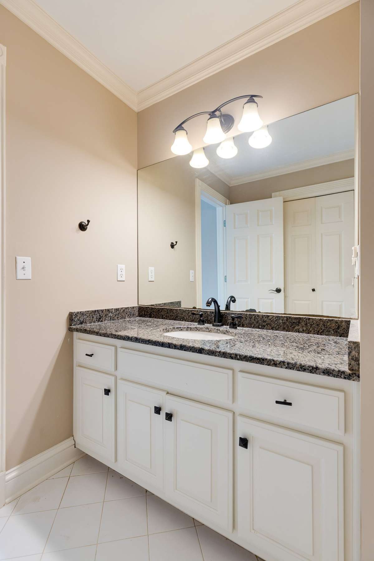 granite with bronze faucet and vanity light