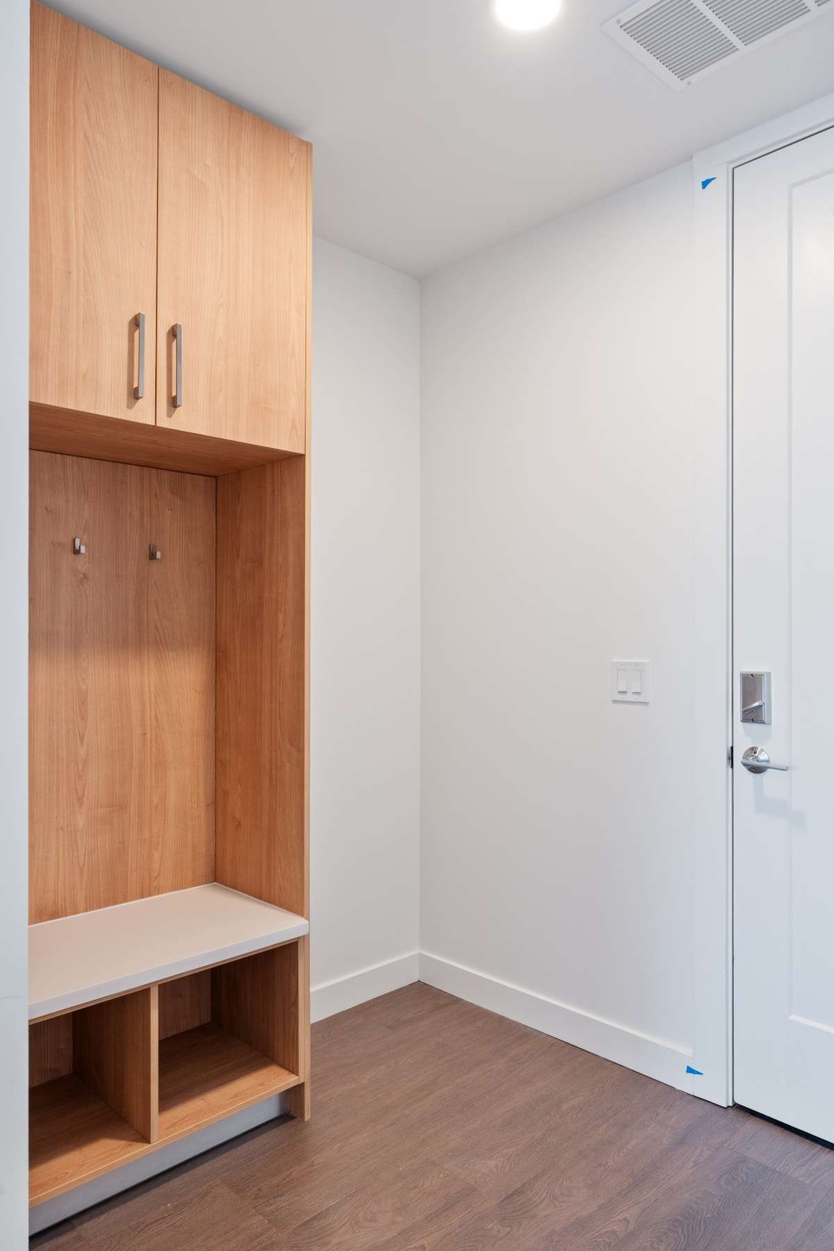 The entry features a custom built-in mudroom with sleek cabinetry, hooks, and open cubbies.