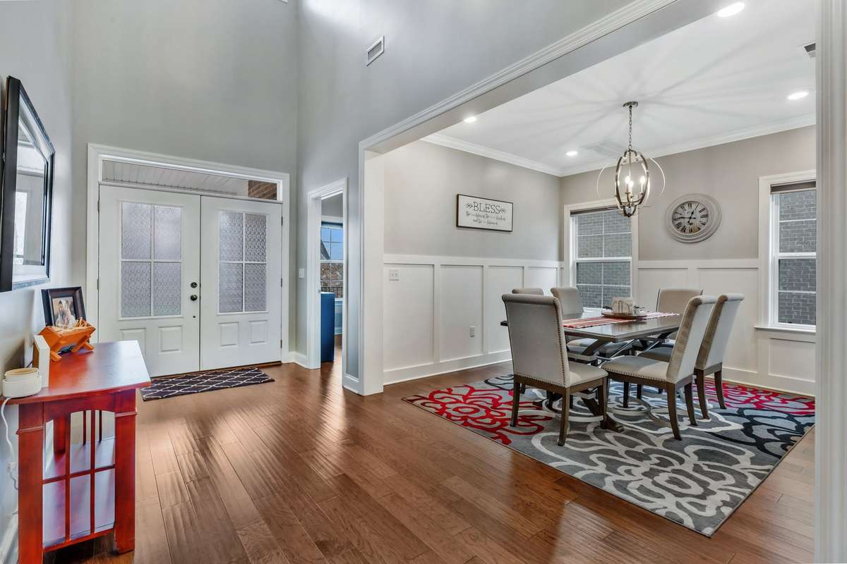 Soaring ceilings in entry with double doors and transom window.