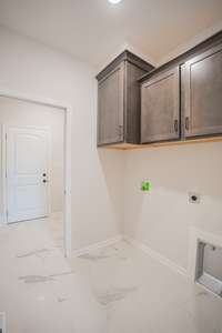 Spacious Laundry Room with Tile Flooring, Shelving and a Laundry Chute!