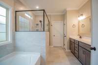EXAMPLE>>>Primary Bathroom Features a Huge Tile Shower, Soaker Tub, Large Double Vanity, Huge Walk-in Closet, Tile Flooring, Crown Molding, Linen Closet and a Toilet Room!