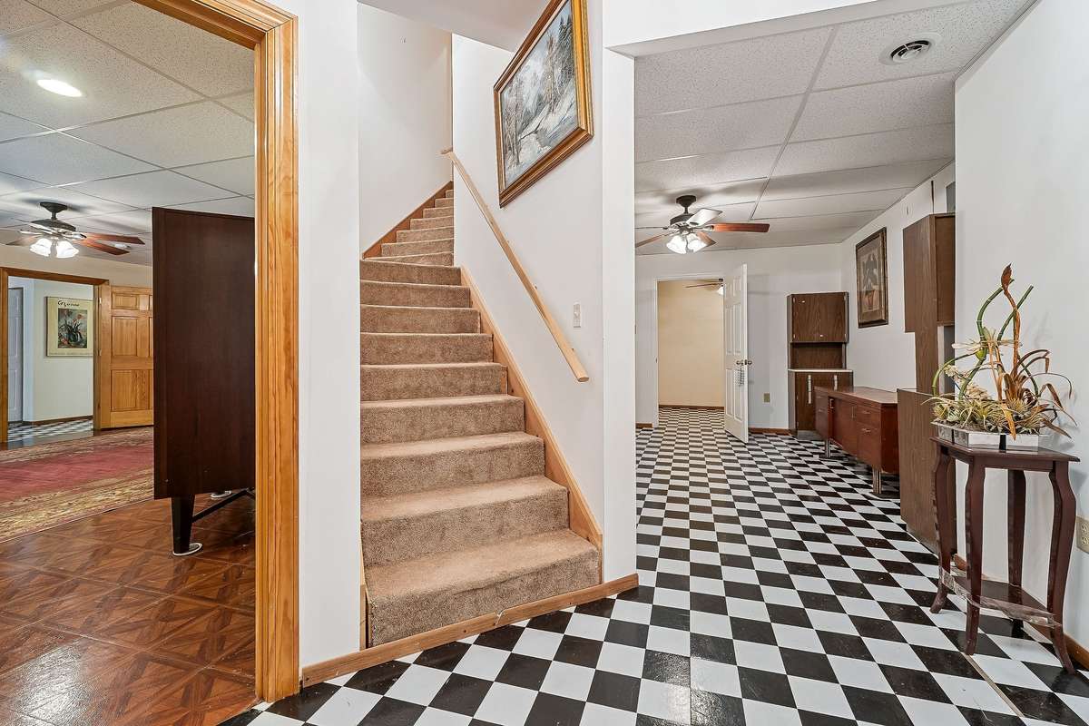 The owners finished the entire basement except for the garage.  This photo shows the steps leading to the basement along with this large room that could be used as a foyer, office, playroom, or rec. room.