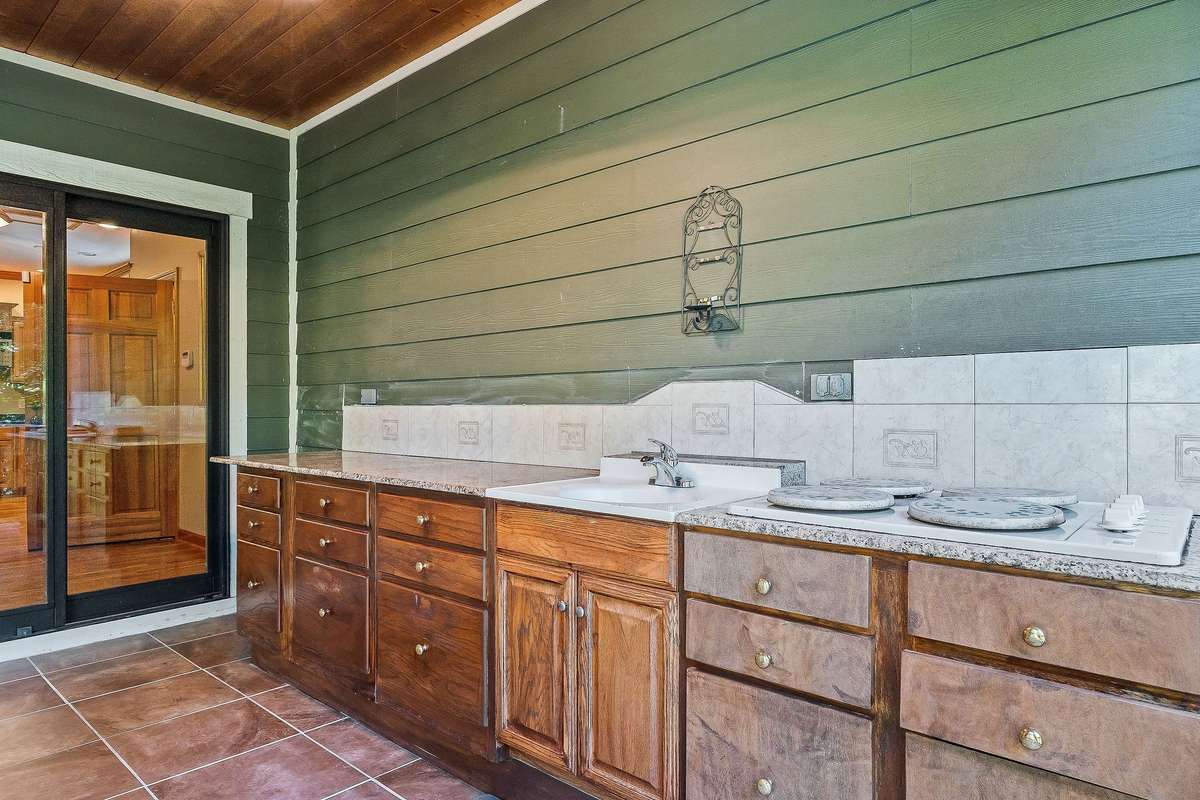 The outdoor kitchen has a sink and plenty of room to prepare and cook for guests.