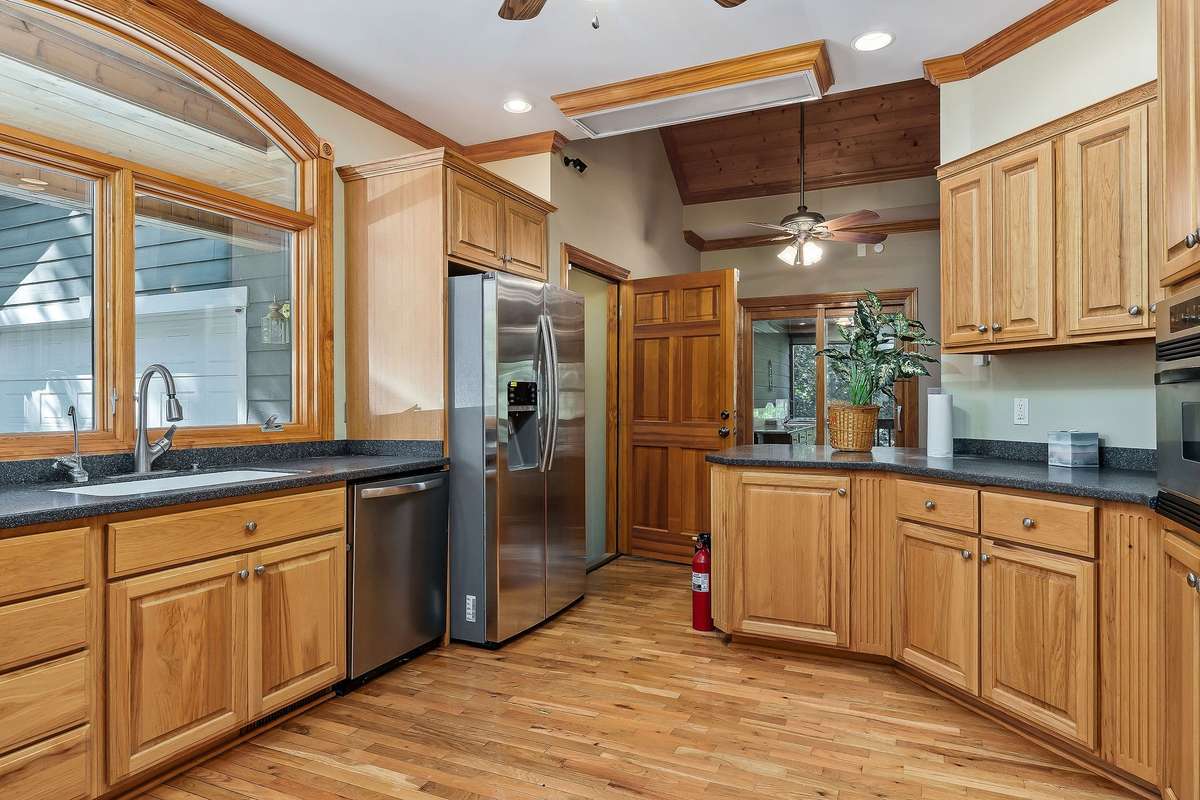 The large kitchen window and doors leading to the outdoor covered porch provide plenty of light to the home.