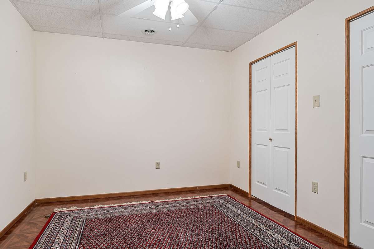 This is another downstairs room with two closets, a ceiling fan, and could be used as a bedroom, office, or hobby room.