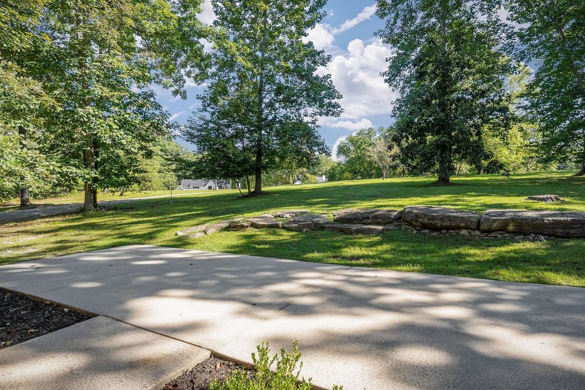The view of the large front yard, which features a bonus rock formation.