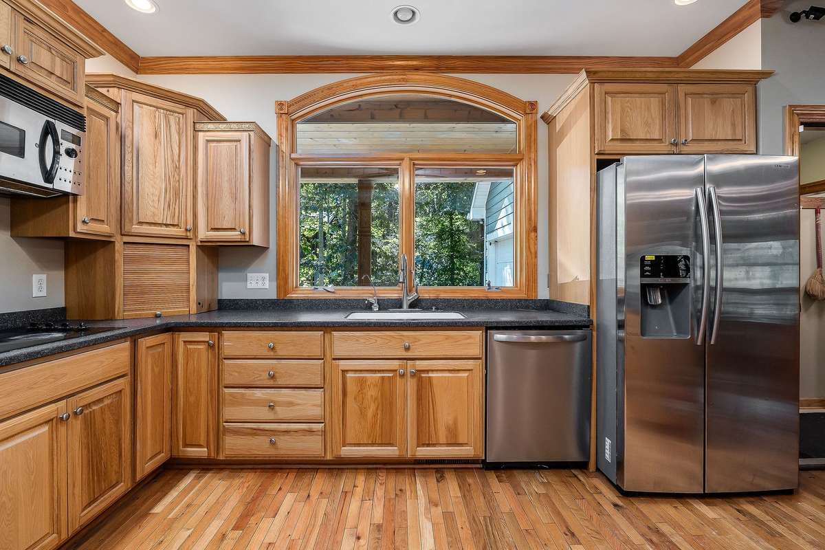 The kitchen features beautiful hardwood floors, a great view, and appliances to remain with the home.