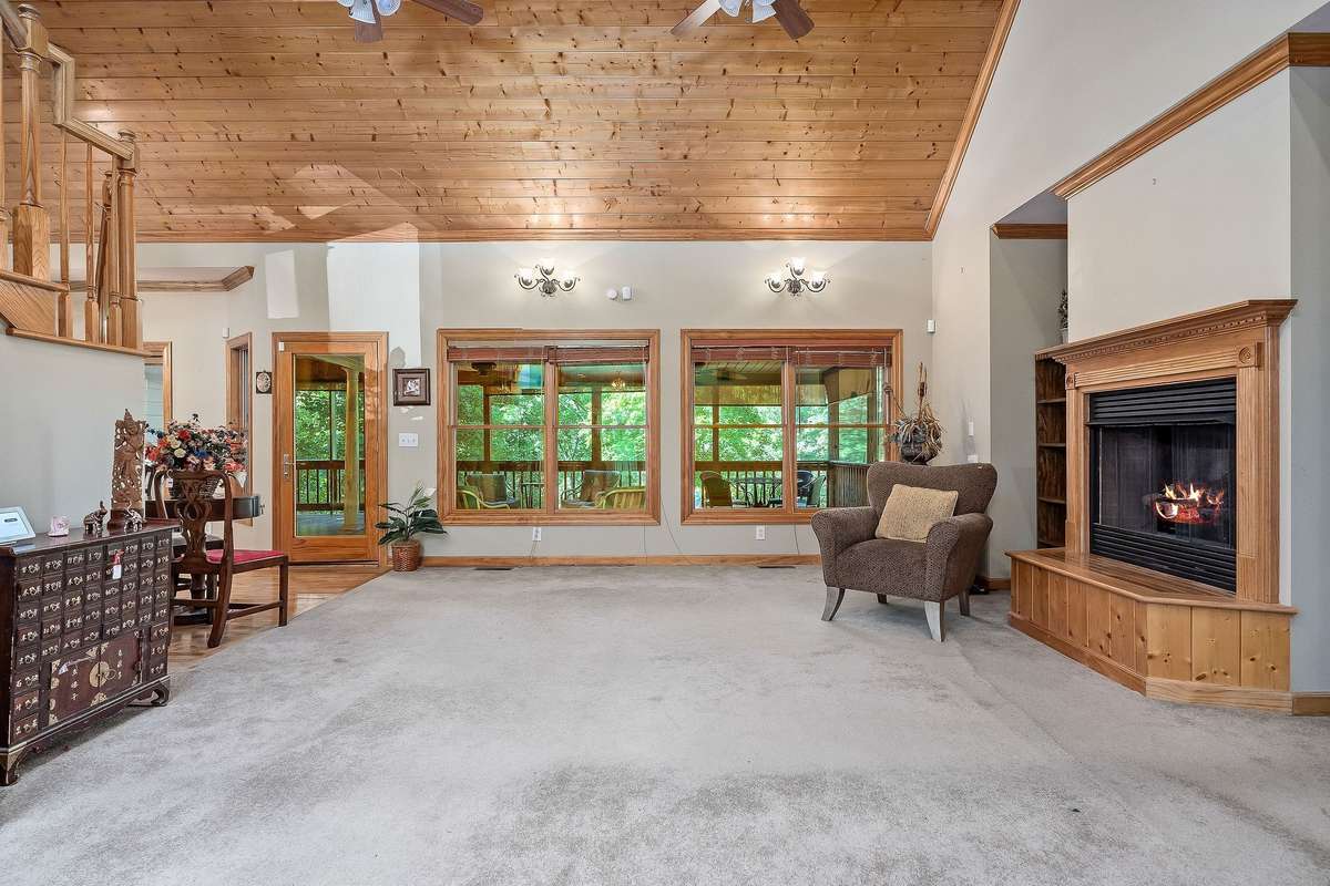 When you enter the large living room, your eyes are immediately drawn to the vaulted wood ceilings, the fireplace, and the screened porch the sellers added in 2013.