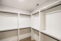 Primary closet is huge and custom wood shelving provides lots of storage~