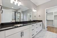 Luxurious primary bathroom showcasing sleek black granite countertops