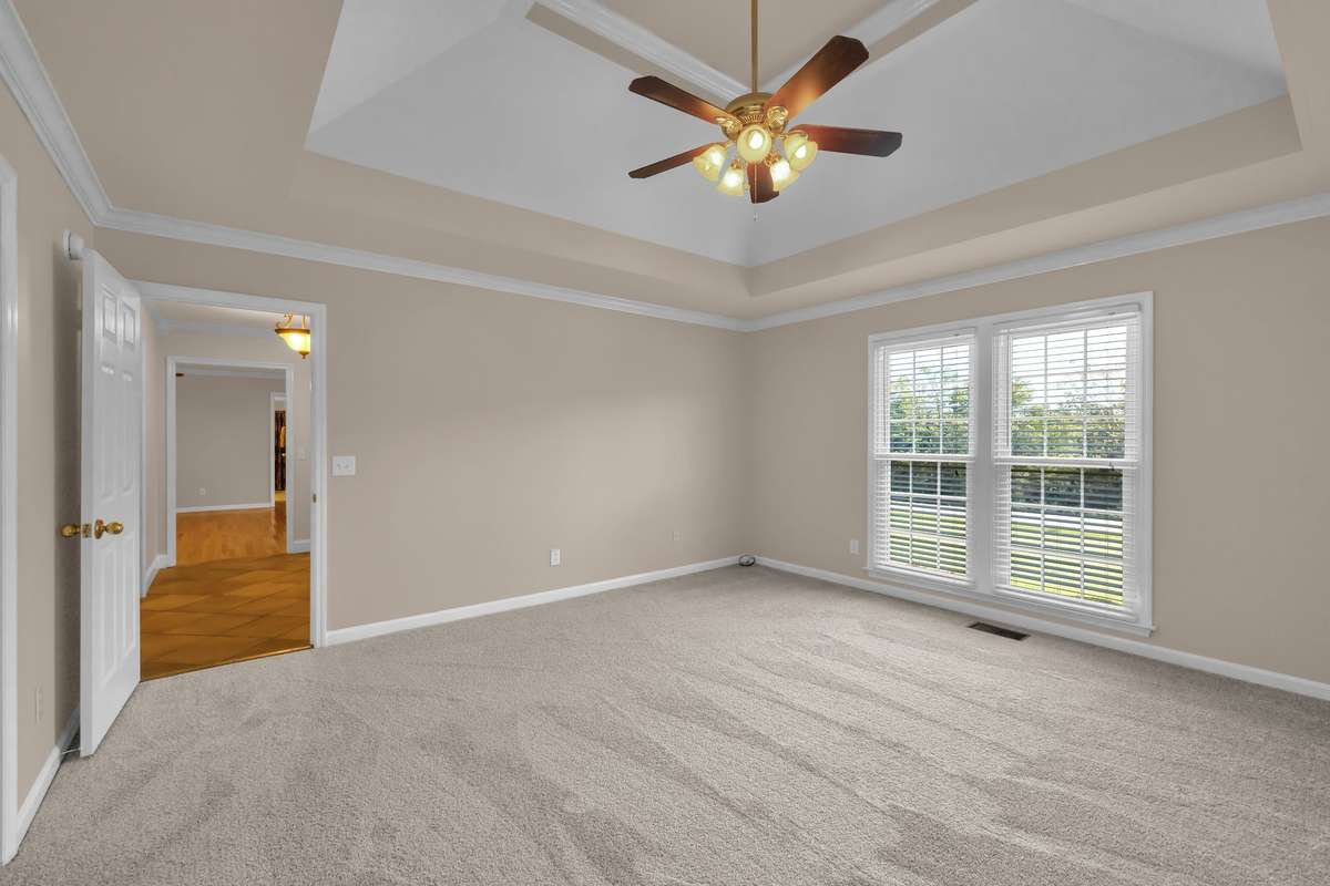 Primary Bedroom includes a trey ceiling, ceiling fan, new carpet, full bath and two walk-in closets.
