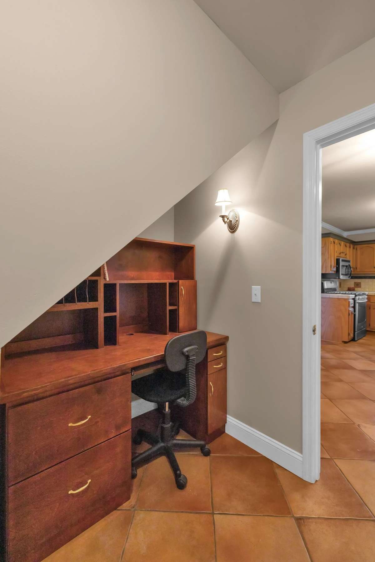 Nook under the stairs includes a desk for cookbooks or computer area.
