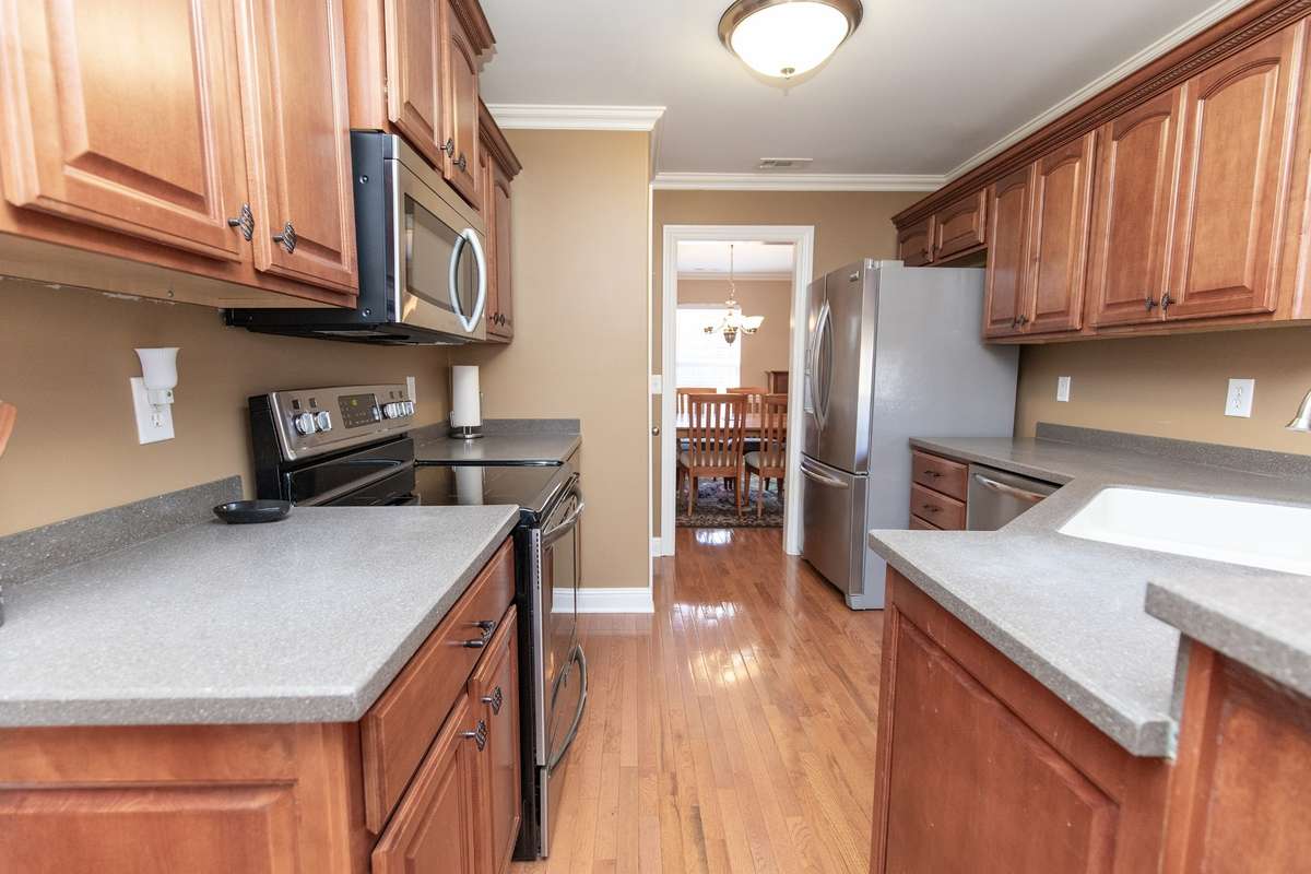 The kitchen boasts gorgeous cabinetry, solid surface counters and stainless appliances