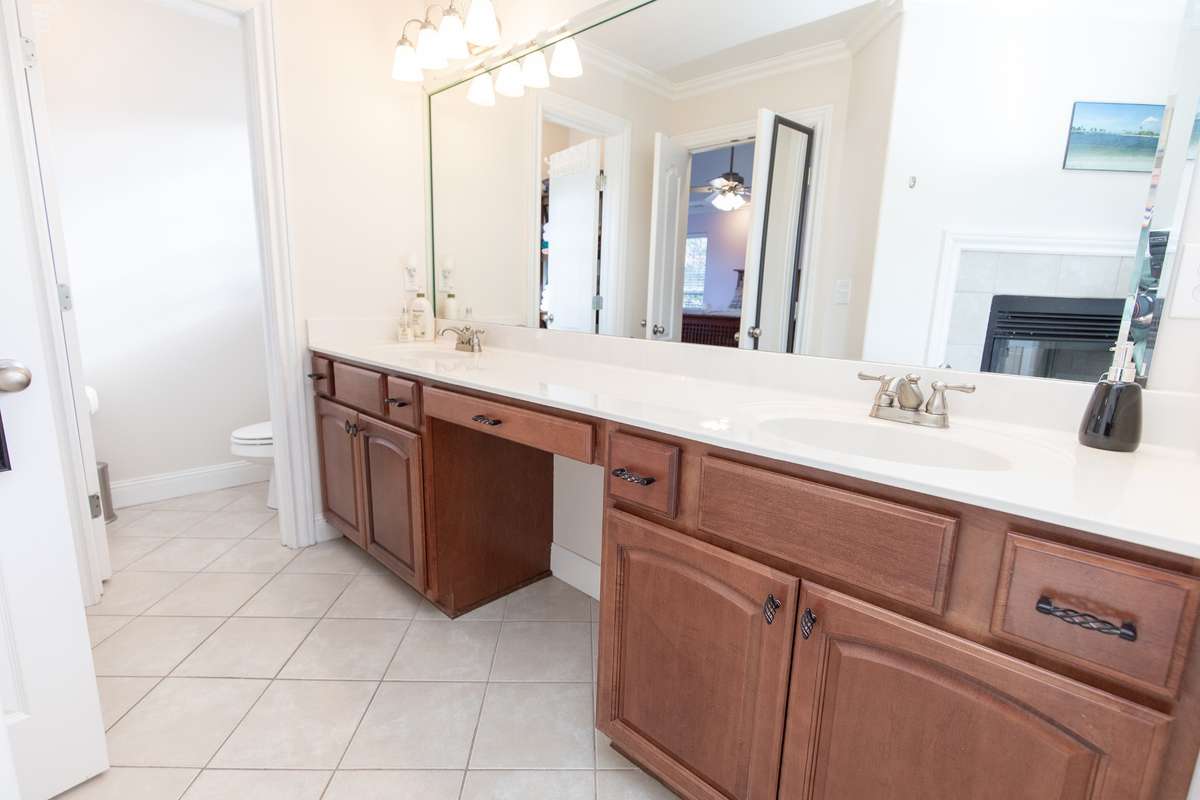 Another view of the his & hers vanity, makeup area, and water closet