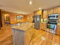 Modern kitchen with island and stainless appliances.  All appliances remain with the home.