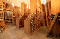 Climate-controlled, 6,500-bottle wine cellar featuring custom redwood racking, Corton limestone flooring, and earthquake-resistant construction.