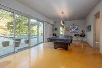 Recreation room with direct access to outdoor terrace and pool area, ideal for entertaining or casual gathering.