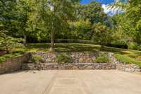 Stone retaining walls frame ample guest parking space. Sculpted grounds maintained by master bonsai artists, emphasizing natural harmony and privacy.