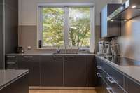 Gourmet kitchen featuring sleek custom cabinetry, quartz countertops, premium appliances, and a functional, modern layout.