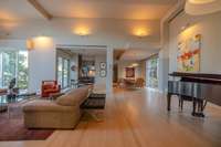 Open-concept living space designed for acoustics and comfort, featuring wide-plank flooring and integrated lighting.