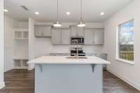 The large great room seamlessly connects to the dining area + spacious kitchen with large island.