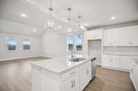 Charming pendant lights hang above the island, offering warm illumination and a welcoming atmosphere.