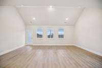 The expansive great room showcases a dramatic vaulted ceiling, creating an open, light-filled atmosphere that elevates the entire space.