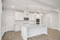 A spacious walk-in pantry is conveniently located just off the gourmet kitchen, offering ample shelving and organized storage for all your culinary essentials.