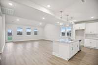 The sun-filled open-concept layout seamlessly connects the great room, dining area, and gourmet kitchen, creating an ideal space for entertaining and everyday living with a sophisticated, airy ambiance.