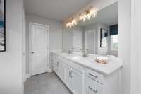 ***Photo taken from previously built home - options and colors may vary***

The Owner's Bath also includes double sinks with quartz countertops and tile flooring.