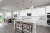 ***Photo taken from previously built home - options and colors may vary***

The island offers ample prep space and seating for casual dining or entertaining. Features durable quartz countertops and pendant lighting.