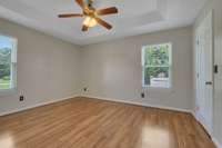 The Primary Bedroom features a ceiling fan, two windows, a tray ceiling, walk-in closet and a full bath.