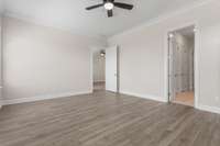 Primary bedroom with hardwood flooring and a ceiling fan