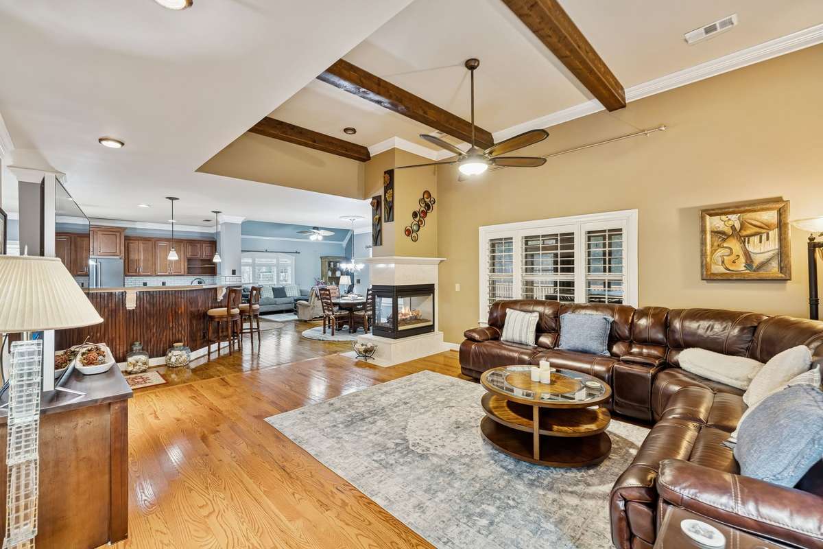 Large open living room features wooden beams and a see thru fireplace for all to enjoy!