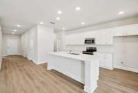 Canyon kitchen and entry way. Photo is of similar home, same plan. Colors, interior selections, elevations, garage swing, and upgrades may vary.