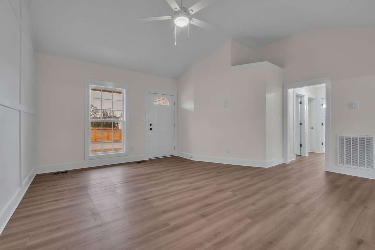 Bright, open living space with luxury vinyl plank flooring throughout — no carpet anywhere.