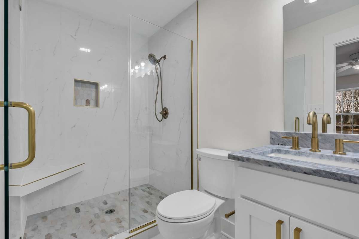 Modern bathroom with quartz countertops, tile flooring, and walk-in shower.