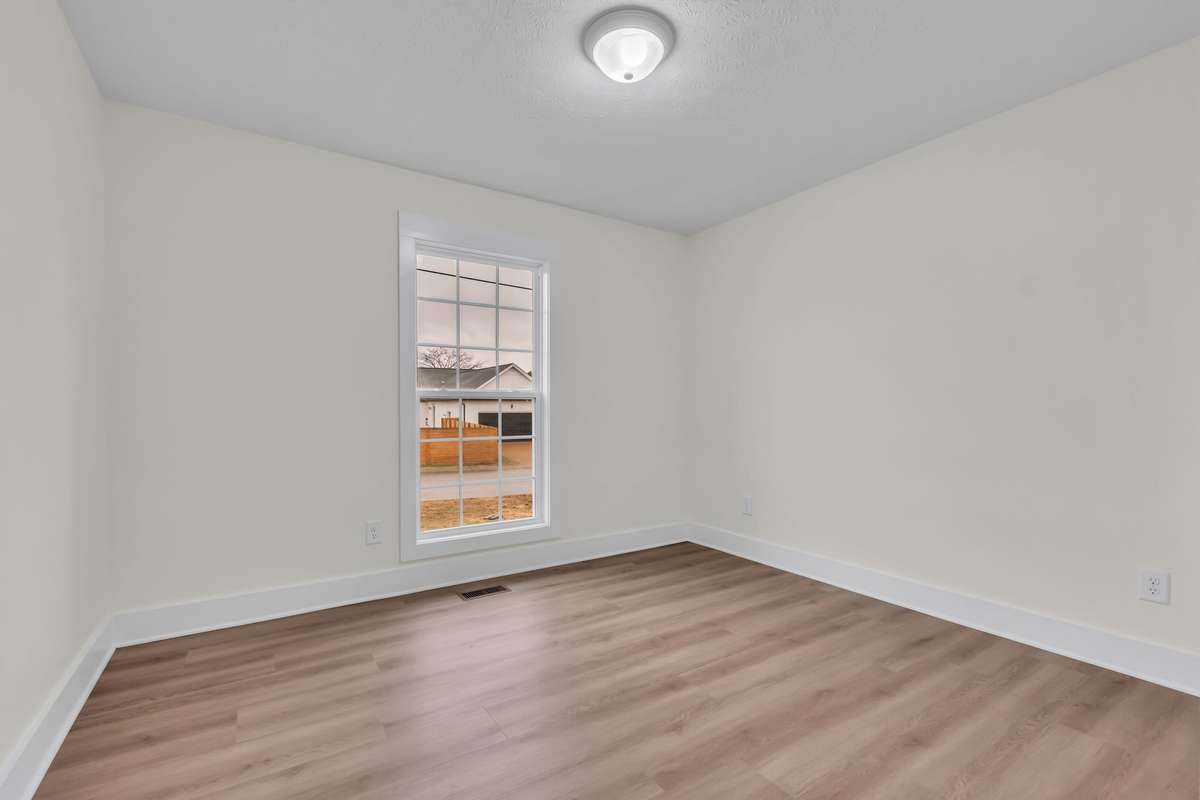 Comfortable secondary bedroom with neutral finishes and LVP flooring.