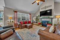 Spacious great room with hardwood flooring, vaulted ceiling and ceiling fan.