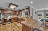 The kitchen boasts a large peninsula island with bar seating, making it an ideal space for entertaining or casual dining. The stove and microwave are new.